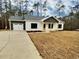 Charming one-story home boasting dark-trim windows, a two-car garage, and lovely yellow-toned support columns at 5374 Hampton Rd., Conway, SC 29527