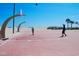 Outdoor basketball court with hoops and a sandy beach in the background on a sunny day at 6001 -1005 S Kings Hwy., Myrtle Beach, SC 29575