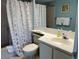 Cozy bathroom with a white vanity, shower and tub, complemented by blue walls and beach themed shower curtain at 645 Retreat Beach Circle, Pawleys Island, SC 29585