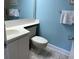 This cozy bathroom has white cabinets, blue walls and neutral tile flooring at 645 Retreat Beach Circle, Pawleys Island, SC 29585