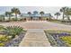 Inviting view of the community clubhouse entrance, landscaped with colorful flowers and palm trees at 645 Retreat Beach Circle, Pawleys Island, SC 29585