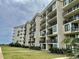 Beautiful multi-story condo building featuring well-manicured lawn and multiple units with private balconies at 645 Retreat Beach Circle, Pawleys Island, SC 29585