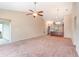 Open-concept living room features neutral carpet, ceiling fan, and connection to the kitchen area at 654 Old Castle Loop, Myrtle Beach, SC 29579