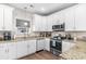 Modern kitchen featuring white cabinets, stainless steel appliances, granite counters and hardwood floors at 685 Tidal Point Ln., Myrtle Beach, SC 29579