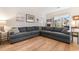 Bright living room features a gray sectional couch, hardwood floors, and natural light at 685 Tidal Point Ln., Myrtle Beach, SC 29579