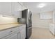 Spacious kitchen boasts stainless steel fridge, white cabinetry, and neutral countertops at 693 Mallard Lake Dr., Myrtle Beach, SC 29577