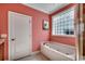 Bathroom featuring tiled floors, soaking tub with jets, glass block window, and decorative art at 702 Compass Point Dr., North Myrtle Beach, SC 29582