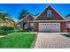 Charming brick home featuring a well-manicured lawn and spacious two-car garage at 702 Compass Point Dr., North Myrtle Beach, SC 29582