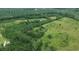 Aerial shot of property showcasing the landscape with mature trees and a red building at 721 Old Buck Creek Rd., Longs, SC 29568