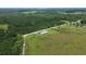 Wide aerial shot of land and a mobile home surrounded by lush trees and a sprawling landscape at 721 Old Buck Creek Rd., Longs, SC 29568