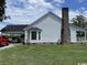 Back exterior view of the house featuring a brick chimney, car port, and manicured lawn at 721 Old Buck Creek Rd., Longs, SC 29568