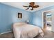 Bedroom featuring a view into the bathroom with a leafy ceiling fan and blue walls at 800 Egret Circle # 34, Little River, SC 29566