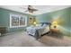 Bedroom featuring light green walls, queen bed, side table, and a leafy ceiling fan at 800 Egret Circle # 34, Little River, SC 29566