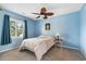 Bedroom with blue walls and leafy ceiling fan and a table lamp at 800 Egret Circle # 34, Little River, SC 29566