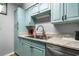 Kitchen featuring blue cabinets, stainless steel sink, gray countertops, and modern appliances at 800 Egret Circle # 34, Little River, SC 29566