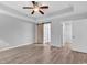 Bedroom featuring tray ceiling, ceiling fan, sliding barn door to bathroom, and doorway to closet at 817 Riverwood Ct., Little River, SC 29566