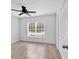 Bright bedroom with wood-look floors, a ceiling fan, and natural light from the window at 817 Riverwood Ct., Little River, SC 29566