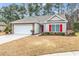 Charming home with red shutters, manicured landscaping, and attached two-car garage at 817 Riverwood Ct., Little River, SC 29566