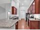 Well-lit kitchen with granite countertops, dark wood cabinets, and modern stainless steel appliances at 817 Riverwood Ct., Little River, SC 29566