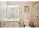 Bathroom featuring double vanity sinks, floral shower curtain, and beach-themed decor at 817 S Ocean Blvd. # 105, North Myrtle Beach, SC 29582