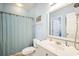 Cozy bathroom with light blue walls, vanity, toilet, and shower with striped curtain at 817 S Ocean Blvd. # 105, North Myrtle Beach, SC 29582