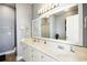 Neutral bathroom featuring double sinks, white cabinets, and a large mirror at 817 S Ocean Blvd. # 105, North Myrtle Beach, SC 29582