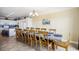 Coastal dining room with a long table, seating for twelve, and white kitchen in the background at 817 S Ocean Blvd. # 105, North Myrtle Beach, SC 29582