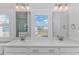 Bright bathroom with double sinks, white cabinetry, and a view from the window at 89 Enclave Pl., Pawleys Island, SC 29585