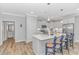 Bright kitchen island with barstool seating, stainless steel appliances, white cabinets, and hardwood flooring at 89 Enclave Pl., Pawleys Island, SC 29585