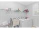 Functional laundry room with a utility sink, washer, dryer, and wire shelving for storage at 89 Enclave Pl., Pawleys Island, SC 29585