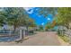 Scenic view of the neighborhood entrance with lush trees and shrubs along a paved road at 89 Enclave Pl., Pawleys Island, SC 29585