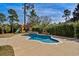 Backyard pool with waterfall feature, slide, and mature trees at 900 Berwick Ln., Myrtle Beach, SC 29579