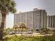 Low angle exterior shot of a condominium with palm trees and parking in front at 9820 Queensway Blvd. # 1502, Myrtle Beach, SC 29572