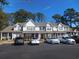 Exterior of a townhouse with a blacktop parking lot and blue skies and mature trees in the background at 1027 Pinwheel Loop # 3103, Myrtle Beach, SC 29577