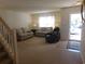 Living room features neutral walls, carpet, two sofas, a recliner, and a front door with natural light at 1027 Pinwheel Loop # 3103, Myrtle Beach, SC 29577