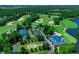 Aerial view of golf course community with clubhouse, blue rooftops, ample parking, water features, and lush greenery at 118 Ellington Ln., Pawleys Island, SC 29585