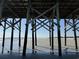Under the pier shows a beautiful sky and a sandy beach at 118 Ellington Ln., Pawleys Island, SC 29585