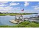 A charming covered dock on the water with seating and an American flag flying proudly in the neighborhood at 118 Ellington Ln., Pawleys Island, SC 29585