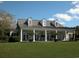 Inviting exterior view of a luxury home featuring dormer windows, a metal roof, and column-lined porch with manicured landscaping at 118 Ellington Ln., Pawleys Island, SC 29585