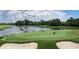 Golfers putting on a lush green with mature trees surrounding the water hazard and sand traps in view at 118 Ellington Ln., Pawleys Island, SC 29585