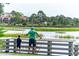 A father and son spend time fishing on the neighborhood pier overlooking a calm channel and marsh grasses at 118 Ellington Ln., Pawleys Island, SC 29585
