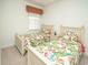 Bright bedroom featuring twin beds with floral bedding and window at 121 Waypoint Ridge Ave. # P-23, Little River, SC 29566