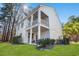 Two-story white home featuring double porches, bright green lawn, and lush landscaping at 125 Harbor Oaks Dr., Myrtle Beach, SC 29588