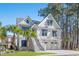 Charming two-story white home with a dual garage, stairway entry, blue awnings, and beautiful landscaping at 125 Harbor Oaks Dr., Myrtle Beach, SC 29588