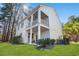 Charming two-story white home featuring a spacious covered balcony and a well-manicured lawn at 125 Harbor Oaks Dr., Myrtle Beach, SC 29588