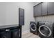 Functional laundry room with modern washer, dryer, cabinetry, and stylish herringbone backsplash at 125 Harbor Oaks Dr., Myrtle Beach, SC 29588