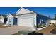 Side view of a blue single-story home with a well-manicured lawn, gravel accents and a two-car garage at 127 Clover Walk Dr., Conway, SC 29526