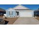 Charming blue single-story home with a well-manicured lawn, gravel accents and a two-car garage at 127 Clover Walk Dr., Conway, SC 29526