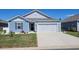 Charming blue single-story home with a well-manicured lawn, white gravel accents and a two-car garage at 127 Clover Walk Dr., Conway, SC 29526