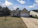 Inviting single-story home with a well-manicured lawn and a paved driveway on a partly cloudy day at 13 Daniel Morrall Ln., Georgetown, SC 29440